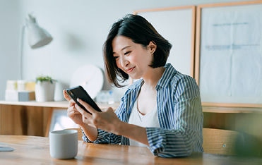 Person with mobile phone and coffee at table